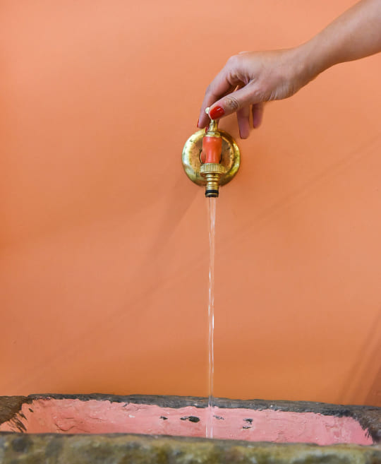 Hand opening a water tap